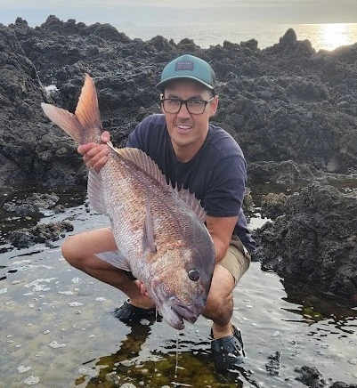 Jesse out fishing, holding a snapper